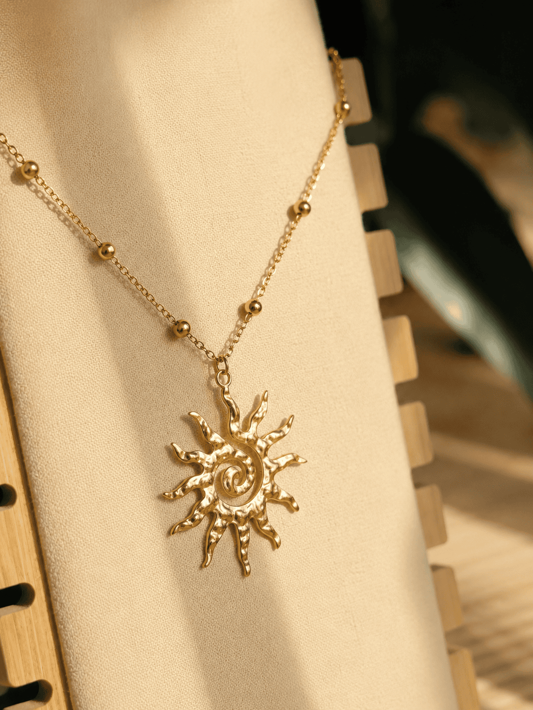 Collier Vaya doré en acier inoxydable avec pendentif soleil sur chaîne perlée.